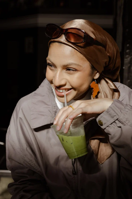 Individual holding a Suna tea latte infused with premium Japanese tea and whey protein isolate