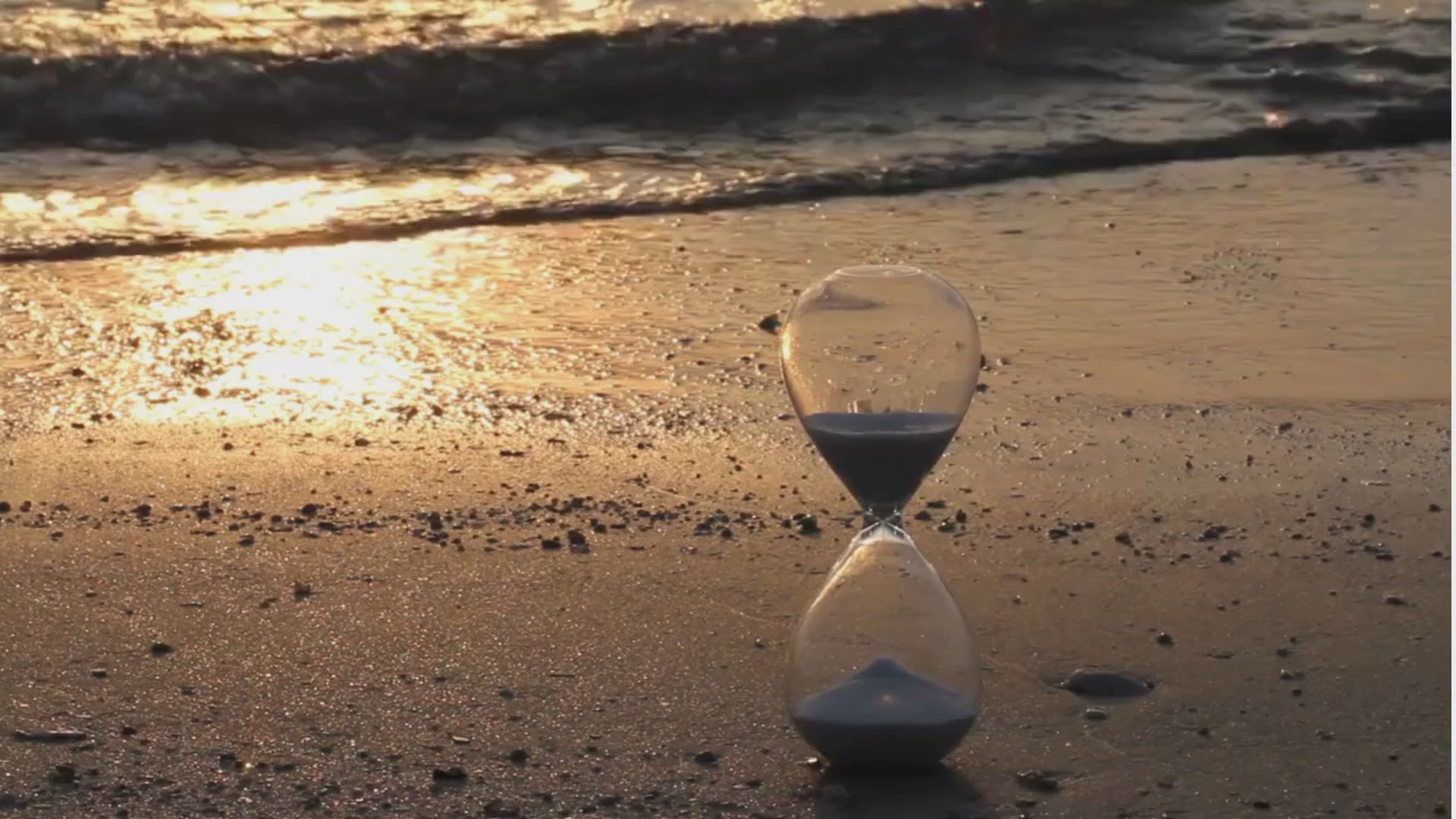 Hourglass by the beach symbolizing time and wellness, representing Suna’s protein tea blends made with collagen and Japanese tea to fuel your day.